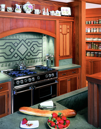 The backsplash behind the stove is a woven design with a Native American bird motif using black and green slate. The sustainably harvested mahogany and oak cabinetry was finished with natural oils for a low luster.